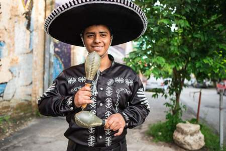 Mexican musician in traditional costume mariachi with maracas on the streetの写真素材