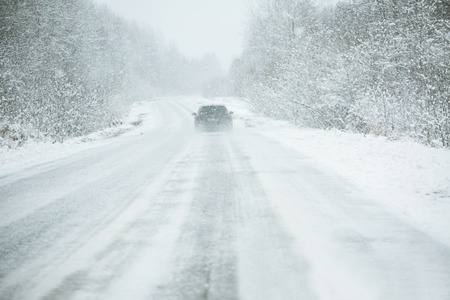 The car is driving on a winter road in a blizzardの写真素材