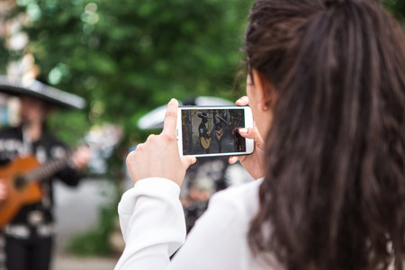 The girl makes selfie with Mexican musicians on the streetの写真素材