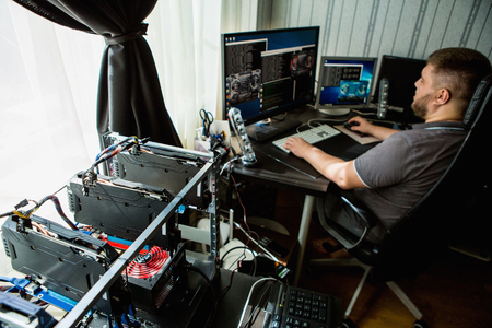 Programmer configures the computer for bitcoin miningの写真素材