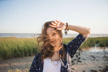 Woman 30-40 years dressed in boho style holding herself by the headの写真素材
