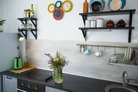 Kitchen in the style of Provence. On the table is a vase with wild flowers.