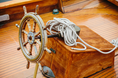 Steering wheel of a wooden vessel on deckの写真素材