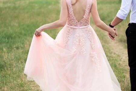 Bride and groom in pink dress embraceの写真素材