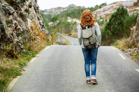 Woman traveler with a backpack on the roadの写真素材
