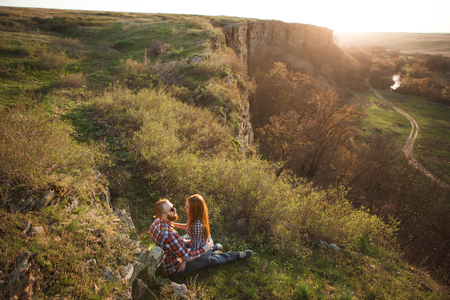 Loving couple walking in mountains park. Girl with read hair, boy with beard.の写真素材