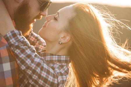 Loving couple walking in mountains park. Girl with read hair, boy with beard.
