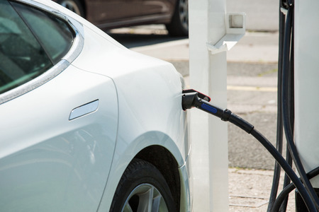 The electric car is charging at the station. Transport network for autotravels.の写真素材