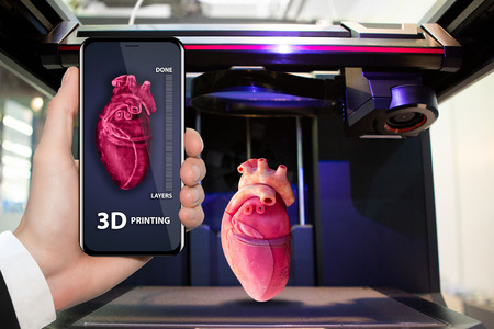 Hand with phone. Application for printing human organs in a 3D printer.