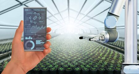 A farmer controls agricultural robotの写真素材