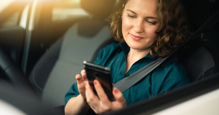 Woman driver with smartphone