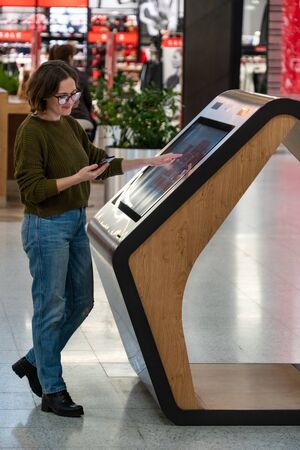 Woman uses the self-service kiosk