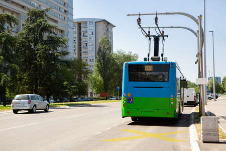 Electric bus at a stop is charged by pantographの写真素材