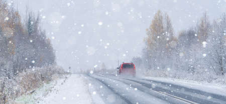 The car is driving on a winter road in a blizzardの写真素材