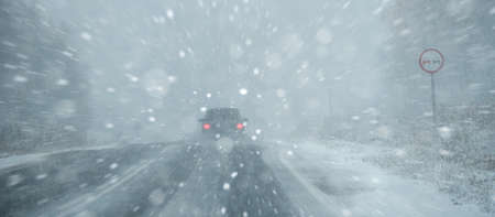 The car is driving on a winter road in a blizzardの写真素材