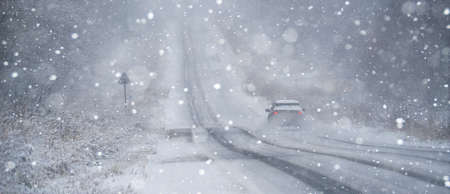 The car is driving on a winter road in a blizzardの写真素材
