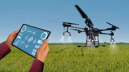Farmer controls drone with a tablet. Smart farming and precision agricultureの写真素材