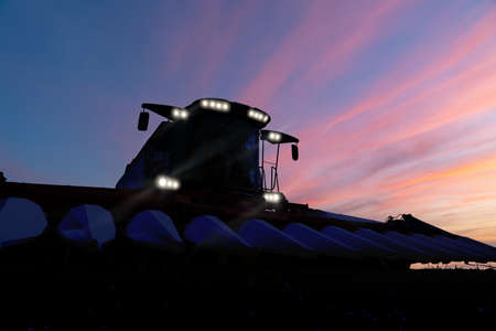 Combine harvester at nightの写真素材