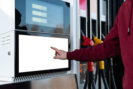 Self-service filling station. A man using a touchscreenの写真素材