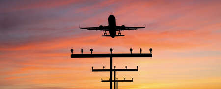 Silhouette of a plane landing at the airport