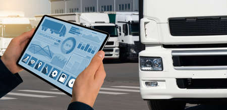 Manager with a digital tablet on the background of trucks. Fleet managementの写真素材