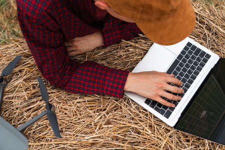 Farmer with laptop and drone on the fieldの写真素材