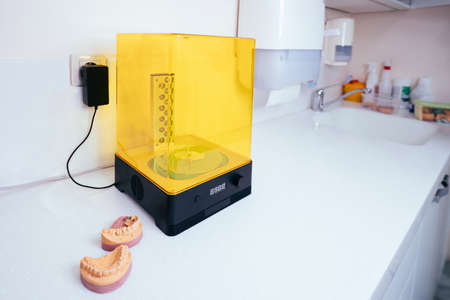 Device for washing a dental 3d print in a cleaning solution, and curing the mold using UV light.の写真素材