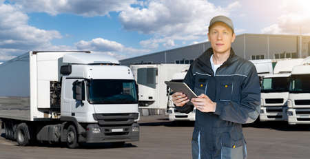 Manager with a digital tablet on the background of trucks. Fleet managementの写真素材