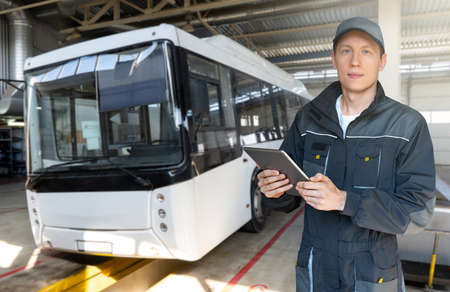Serviceman with digital tablet on the background of the busの写真素材