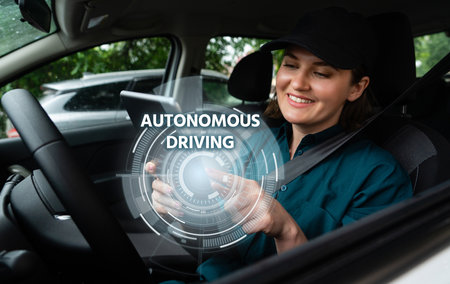 Woman driver controls an autonomous car using a smartphoneの写真素材