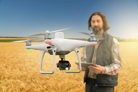 Farmer controls drone with a tablet. Smart farming and agricultureの写真素材