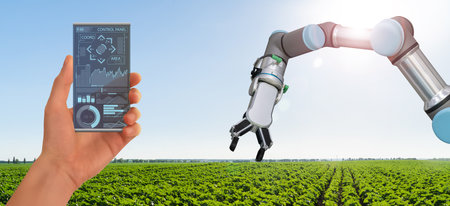 A farmer controls agricultural robot through a smartphone mobile application. Smart farming and digital agriculture 4.0の写真素材