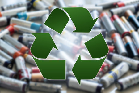 Recycling symbol on a background of used AA battery