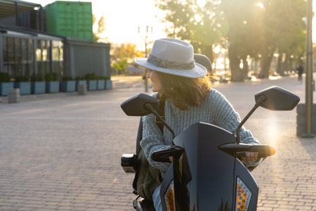 Woman tourist riding a four wheel mobility electric scooter on a city street.