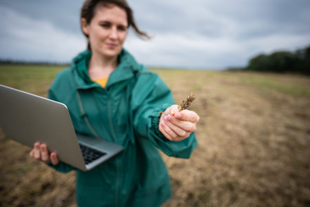 Farmer with laptop on the field. Smart farming and agriculture digitalizationの写真素材