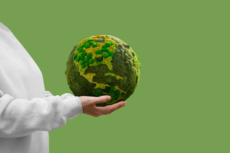 Woman holds a green planet Earth. Symbol of sustainable development and renewable energyの写真素材