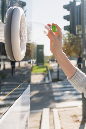 Woman uses a self service machine to receive used plastic bottles and cans on a city street. High quality photoの写真素材