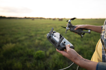 Farmer controls drone. Smart farming and precision agriculture. High quality photoの写真素材