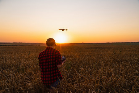 Woman farmer with drone on a wheat field. Smart farming and precision agriculture. High quality photoの写真素材