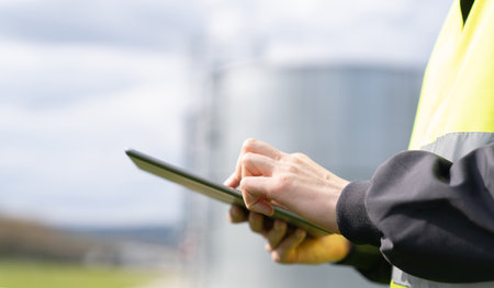Engineer with digital tablet on a background of gas tanks. High quality photoの写真素材