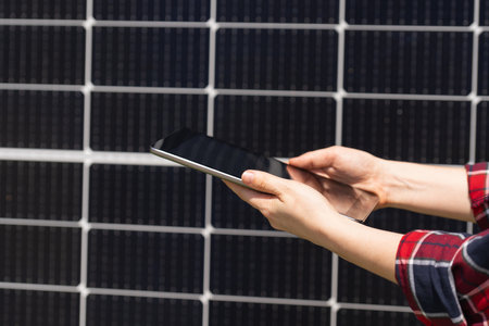 Hands with digital tablet on a background of solar panels
