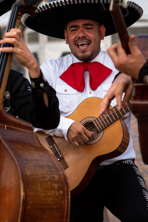 Mexican musician mariachi plays the guitar on a city street.の写真素材