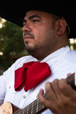 Mexican musician mariachi plays the guitar on a city street..