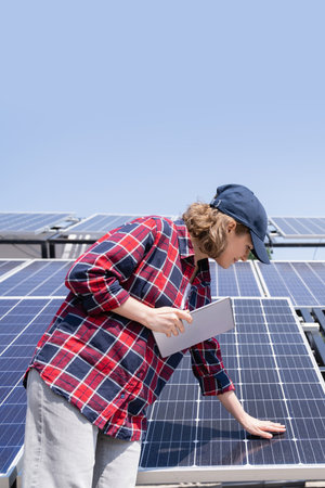 Woman with digital tablet touching solar panel.の写真素材