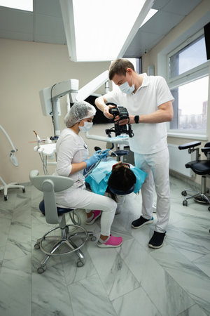 Dentist uses a photo camera to examine a patient.の写真素材