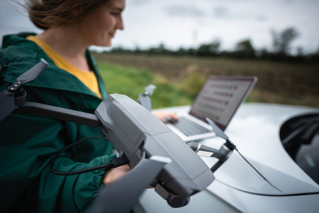 A woman with a laptop and drone.