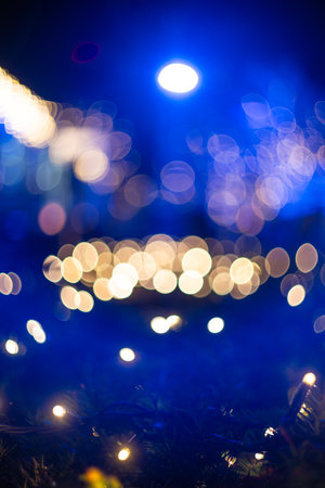 Blurred holiday background with bokeh. Defocused New Year and Christmas illuminationの写真素材