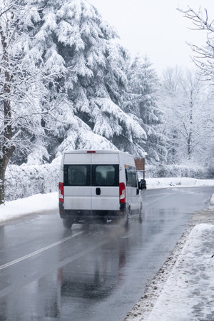 Car on a winter road with snow-covered treesの写真素材