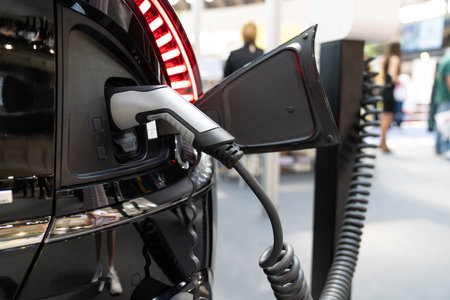 Close up of electric car inlet with a connected charging cable.