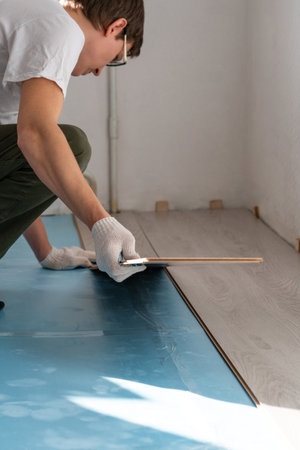 Man is repairing the floor in the house, laminate flooring..